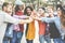 Young millennials friends stacking hands together - Happy students celebrating together - Youth lifestyle, university, social