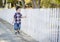 Young Mixed Race Boy Walking with Stick Along White Fence