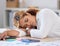 Young mixed race businesswoman sleeping while working in an office at work. One stressed hispanic businessperson taking