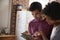 Young mixed race couple studying tablet in kitchen, close up