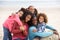 Young mixed race family embracing on beach