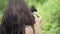 Young mixed race female indie film maker shooting in a green natural setting with grass on background