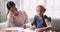 Young mixed race female tutor teaching little girl drawing.