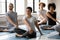 Young mixed race people doing simple seated twist exercise.