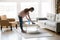 Young mixed race woman cleaning table with cleanser and rag.