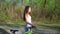 Young mixed race woman cyclist with mountain bike walking in the forest tired cycling workout outdoor.