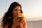 Young mixed race woman drinking cocktail on beach