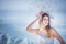 Young model in luxurious strapless corset ball gown sitting on slabs of broken ice at the frosty seaside. Winter