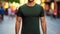 Young model shirt mockup, boy wearing green t-shirt on street in daylight. Shirt mockup template on hipster adult for design print