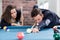 Young modern couple playing pool table billiard game