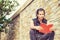 Young Modern East Indian American Man reading red book outside in New York City