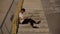 Young modern happy man without shoes, sitting on urban stairs, using laptop, wearing black cap and socks