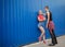 Young modern stylish hipsters couple on blue background, sunny portrait couple teenagers.