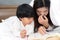 Young mom and daughter telling storybook in bed