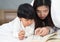 Young mom and daughter telling storybook in bed