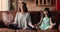 Young mom her daughter do meditation practice at home