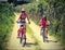 Young Mom and little girl on bicycles on the narrow road