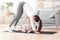 Young mom practicing yoga at home with little son, making back stretching exercise