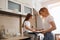 Young mommy teaching her child to cook cookies in the kitchen