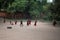 Young monks plays with a tire and throwing stick through it