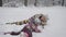 Young mother admires her baby who have fun playing in the snow. Little girl actively spends time in the winter.