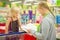 Young mother and adorable daughter in shopping cart select kids