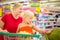 Young mother and adorable girl in shopping cart looks at giant j