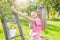 Young mother with baby picking apples from an apple tree