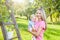 Young mother with baby picking apples from an apple tree