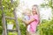 Young mother with baby picking apples from an apple tree