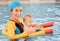 Young mother and baby son are in pool teaches swim