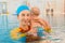 Young mother and baby son are in pool teaches swim