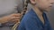 Young mother braiding small daughter hair, preparation before school, close-up