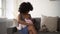 Young mother breastfeeding little baby and sitting on couch in apartment room spbd.