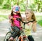 Young mother calms the sad daughter who did not get to ride a bike