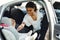 Young mother checking safety belts on baby car seat