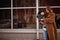 Young mother with child on hands walking down streets.