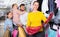 Young mother choosing new dress in shop