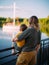 Young mother with cool kid boy stand on dock, look at sailboat. Back view. Summer photography about family and travel