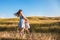 Young mother and daughter dancing and playing in a golden field of sunshine.