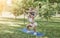 a young mother and daughter are doing sports squats in the park on the grass