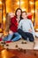 Young mother with a daughter with long hair and an elder son cuddle in the autumn scenery in the studio with pumpkins, plaids and