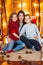 Young mother with a daughter with long hair and an elder son cuddle in the autumn scenery in the studio with pumpkins, plaids and