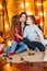 Young mother with a daughter with long hair and an elder son cuddle in the autumn scenery in the studio with pumpkins, plaids and