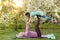 a young mother and daughter perform yoga exercises in the park on a gym mat. healthy lifestyle.