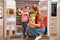 Young mother with daughter putting food into refrigerator