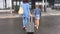 Young mother and daughter with tourist suit go to airport suitcase back view