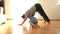 Young mother does physical yoga exercises together with her toddler boy at home on the floor during the covid-19