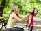 Young mother dresses her daughter\'s bicycle helmet