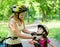 Young mother dresses her daughter\'s bicycle helmet